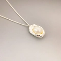 Minimalist silver necklace featuring organic metal charm with a white freshwater pearl - Silver