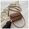 Bolso bandolera cuadrado de cuero marrón con solapa frontal sobre tela blanca lisa - Marrón