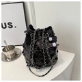 Close-up of black sequined bucket bag with drawstring closure and silver chain strap - Black