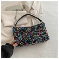 Detail einer bunten Pailletten-Handtasche mit Kettenriemen und silbernen Beschlägen - bunt