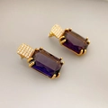 Macro shot of large purple rectangle gemstone earrings with gold prong settings and micro-pave - Blue and Purple
