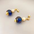 Detailansicht von Vintage-Ohrhängern mit blau-goldenen Perlen und weißen Akzenten - Blau