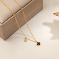 Elegante gouden klaverketting met zwarte onyx hanger gepresenteerd op een luxe sieradendoos - Goud-Zwarte Schelp