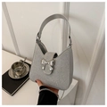 Close-up of sparkling silver rhinestone handbag with metallic bow and chain strap - Silver