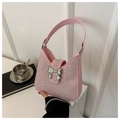 Detail of pink rhinestone crossbody bag featuring a silver metal bow clasp and chain - Pink