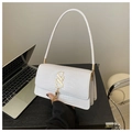 Detailed view of white crocodile pattern texture with golden logo and tassel on handbag - White