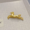 Luxuriöse goldene Pferde-Brosche mit funkelnden Zirkonen auf weichem Hintergrund - Gold