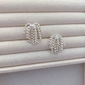 Elegant silver fringe tassel drop earrings with beaded cluster design on beige display - Silver