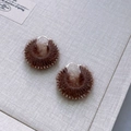 Detailed close-up of brown wool woven drum earrings with silver beaded trim and metal hooks - Teddy Bear