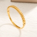 Golden stainless steel open bangle featuring continuous cutout bear silhouette patterns - Fishbone Shape Bangle