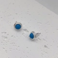 Detailaufnahme silberner Ohrstecker mit türkisblauen Steinen und strukturierten Rändern - Blauer Sodalith
