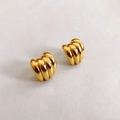 Detalle de pendientes de botón tipo croissant chapados en oro 18K con textura espiral - Dorado