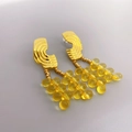 Elegante Ohrhänger aus Gold-Messing mit Bernsteinperlen und dreistufigen Quasten auf Grau - Gold