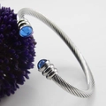 Brazalete de cable de acero inoxidable con piedras azules sobre un fondo blanco limpio - Color Acero