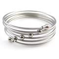 Close-up of silver multilayer spiral steel wire bracelet with metal beads and water drop ends - Steel