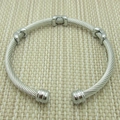 Vue détaillée d'un bracelet câble torsadé argenté avec des ornements en métal lisse - Couleur Acier