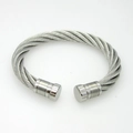 Macro detail of twisted titanium steel cable bracelet with cylindrical end caps - Steel
