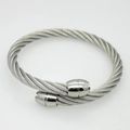 Macro detail of silver twisted cable cuff bracelet with smooth cylindrical metal end caps - Steel