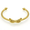 Poliertes goldener Edelstahl-Armreif mit zentralem Knotendesign und Kugelenden - Gold