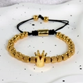Detalle de pulsera de cuentas con corona dorada y cuerda negra en bandeja de cerámica - Pulsera de cuentas tejida / Corona Dorada