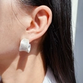 Κοντινό πλάνο από ασημί φαρδύ σκουλαρίκι σχήματος C με ματ υφή πάνω στο μοντέλο - Κυματιστό Στριφτό Πλατύ Σχήμα C (36) / Αντικέ Ασήμι