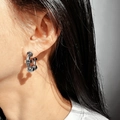 Close-up of industrial style hexagonal screw C-shaped earring on model ear - White Gold