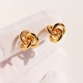 Minimalist gold knot earrings with triple intertwined circles on a neutral background - Gold