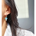 Gepolijste metalen oorring met lichtblauwe gestipte paddenstoelhanger op model - Blauw