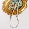 Elegant white gradient pearl necklace draped on vintage golden frame with shadow - Gradient White Pearl Style (964)