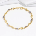 Close-up of golden bracelet featuring wavy hollow metal links and purple zircon stones - Purple Main Stone (TS0363) / Purple Bracelet (TS0363)