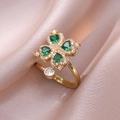 Close-up of golden clover ring with green heart-shaped stones and pavé crystals - Emerald Heart Rotating Ring (J0330)