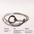 Polished silver knot cuff bracelet in minimalist brass design with smooth curved lines - Platinum-Bangle