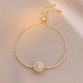 Detail of adjustable gold-tone bracelet with pink daisy charm and pink cubic zirconia - Ts0671-2