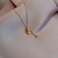 Detailed macro view of a rose gold gourd pendant with tassels and Fu character engraving - Small Gourd (T0054) / Rose Gold