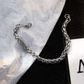 Poliertes Titanstahl-Kettenarmband mit Karabinerverschluss auf stilvollem Hintergrund - Hip Hop Geflochtener Kettenstil / Silber