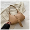 Detail view of khaki hobo shoulder bag with golden buckle on a white blazer background - Khaki