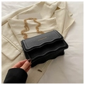 Detail of black pebbled leather crossbody bag with gold chain and scalloped flap edge - Black