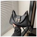 Detail of a black crescent saddle bag with a silver metal bow buckle and matte leather - Black