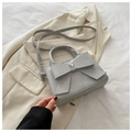 Sac bandoulière bleu-gris clair avec grand nœud et breloque cœur sur un blazer crème - Gris