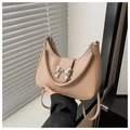 Detail of beige crescent shoulder bag featuring silver bow clasp and metal chain handle - Khaki