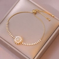 Elegante bracciale regolabile color oro con ciondolo a fiore rotante in zirconi cubici - Fiore Rotante (TS0194) / Oro