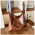 Detail of dark brown PU leather tote bag with vertical stitching on wooden shelf - Yellow Brown
