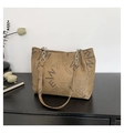 Khaki tote bag with letter print and silver chain strap on a black wooden desk - Khaki