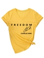 Detalle de camiseta amarilla con cuello en V, estampado Freedom Charlie Kirk y nudo frontal - S / Amarillo (Fuente Negra)
