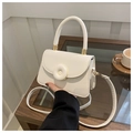 Close-up of a white leather crossbody bag with a unique doughnut-style buckle and handle - White