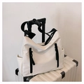 White nylon crossbody messenger bag with black zippers and buckle on a white suitcase - White