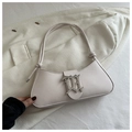 Close-up of cream leather hobo bag with a silver gothic logo on white blazer - White