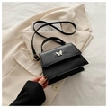 Close-up of black PU crossbody bag with silver butterfly detail on a cream blazer - Black