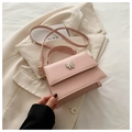 Detail of pink leather handbag with enamel butterfly clasp on a beige blazer - Pink