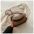 Detailed close-up of a brown quilted saddle bag with heart patterns on a beige blazer - Brown